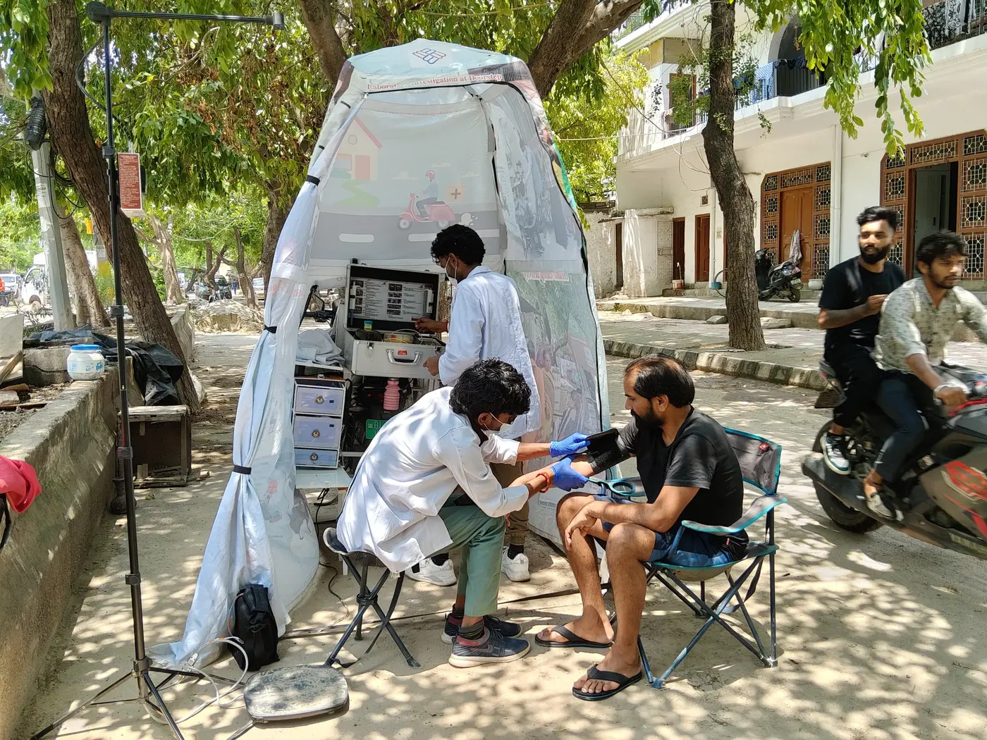 Swasthgram team providing care under a tree in a neighborhood