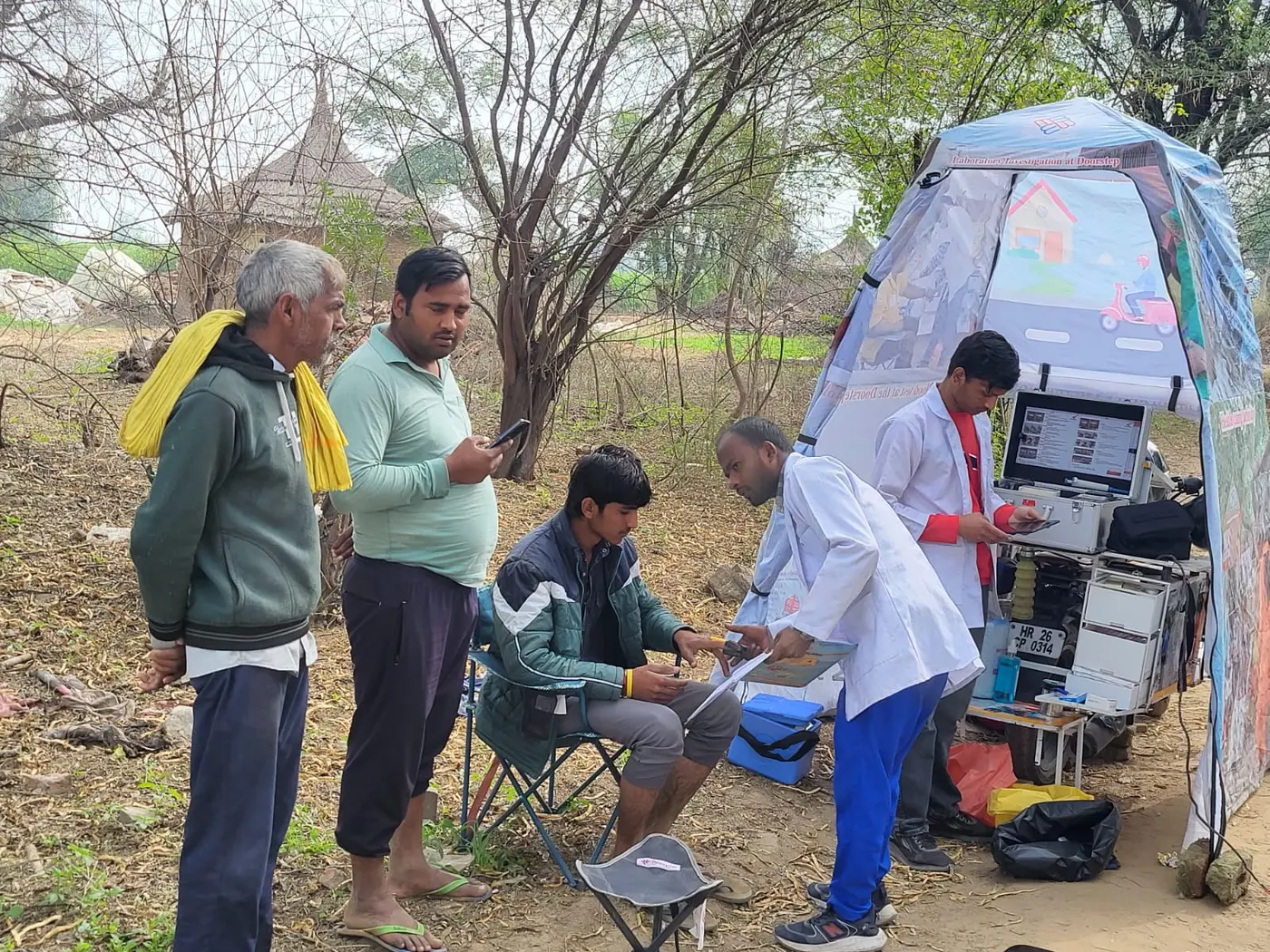 Swasthgram health worker operating a portable LaBike diagnostic setup outdoors