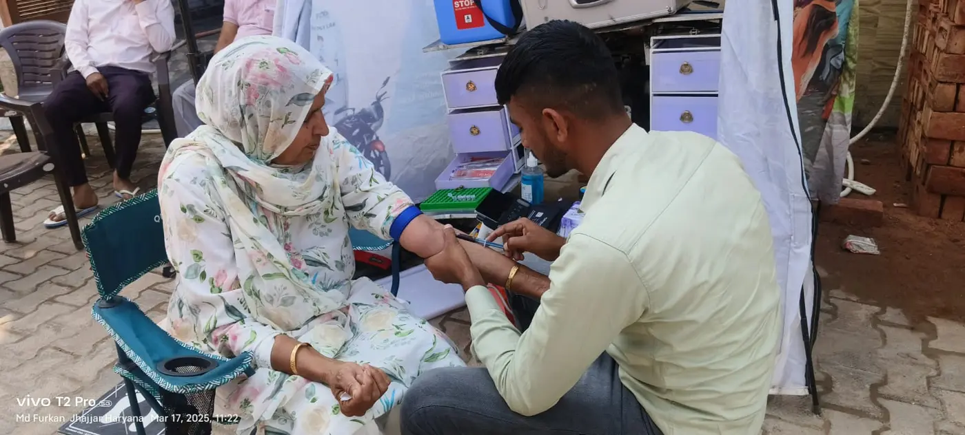 A health worker screening a woman beside the mobile diagnostic unit